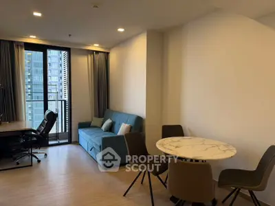 Modern living room with stylish furniture and city view balcony in a high-rise apartment.