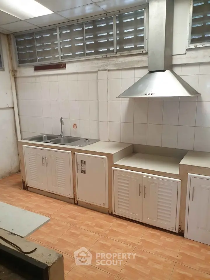 Spacious kitchen with modern range hood and ample storage cabinets