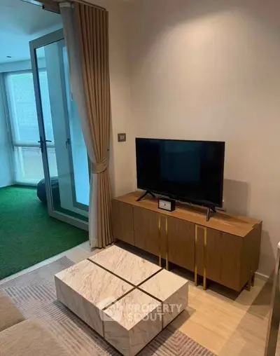 Modern living room with stylish TV stand and marble coffee table, featuring a cozy balcony view.