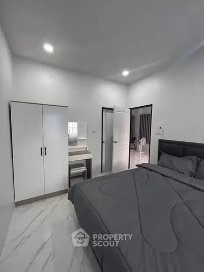 Modern bedroom with sleek design and cozy ambiance, featuring a stylish wardrobe and elegant bedding.