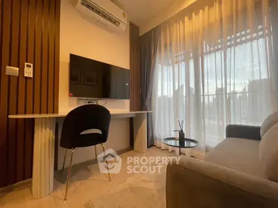 Modern living room with sleek furniture and large window offering natural light.