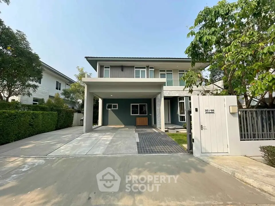 Modern two-story house with spacious driveway and lush greenery in a serene neighborhood.