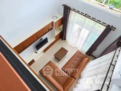 Spacious living room with modern furniture and large windows offering natural light.