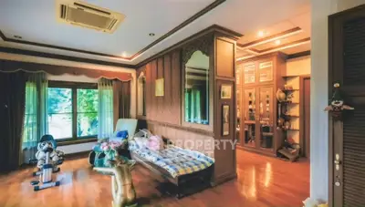 Luxurious living room with elegant decor and wooden flooring, featuring a cozy seating area and large window view.