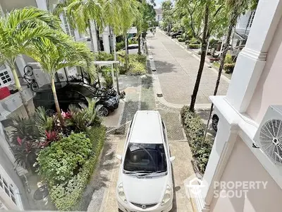 Charming residential street view with lush greenery and parked cars, showcasing a serene neighborhood ambiance.