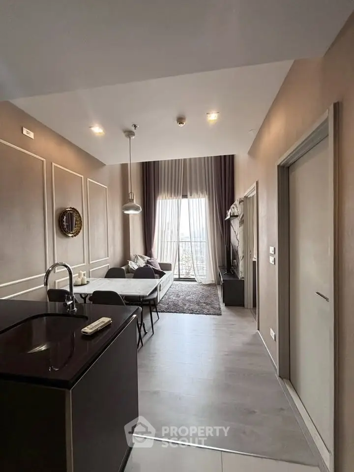 Modern living room with high ceilings and elegant decor, featuring a cozy seating area and large windows.