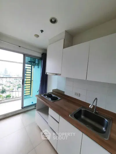 Modern kitchen with balcony view in high-rise apartment