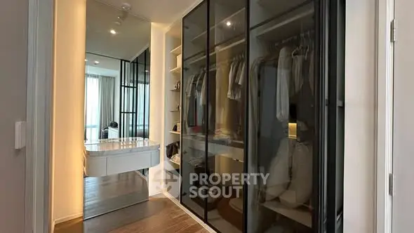 Spacious walk-in closet with sleek glass doors and ample storage space.