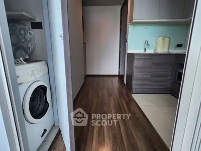 Modern apartment interior with washing machine and sleek kitchen design