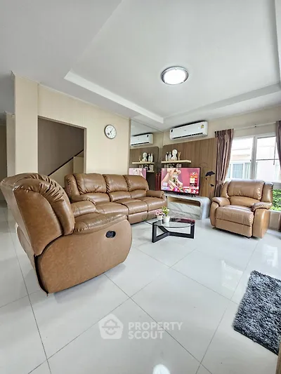 Spacious living room with modern leather sofas and large windows