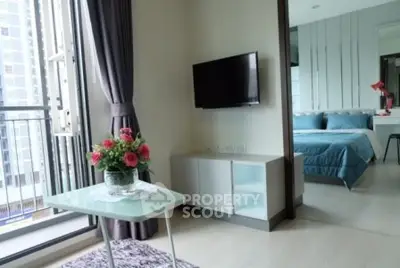 Modern apartment with cozy living area and stylish bedroom, featuring a balcony with city views.