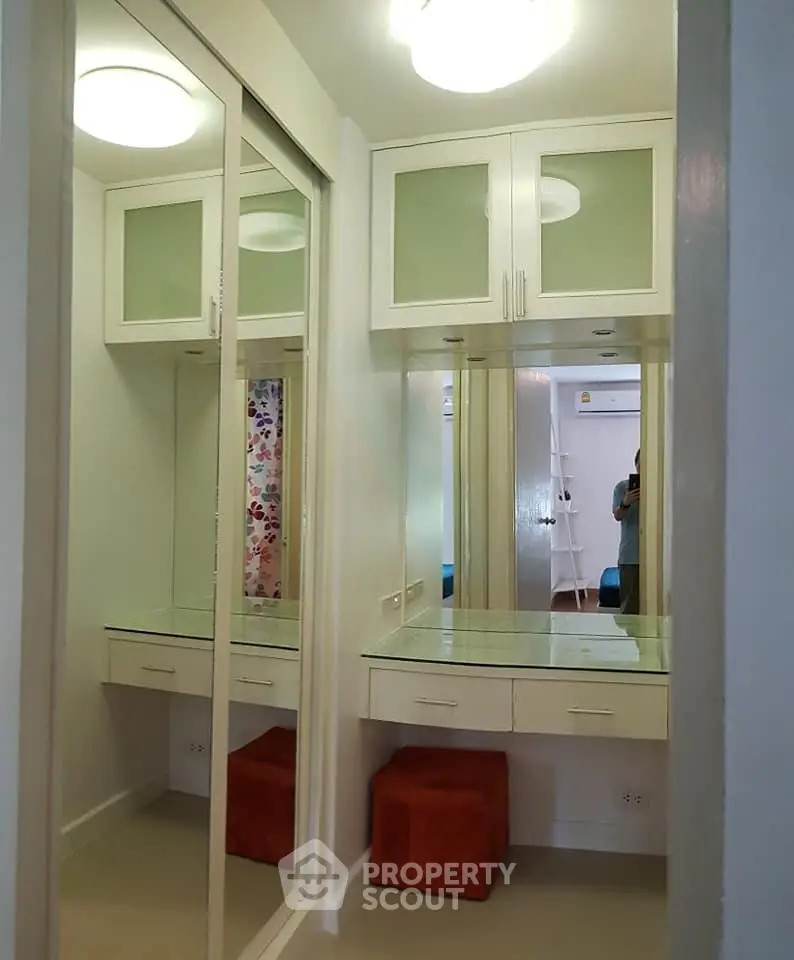 Chic dressing area with mirrored closet and built-in vanity in modern apartment