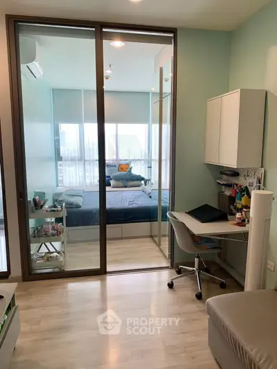 Modern bedroom with study area and glass partition, featuring sleek furniture and natural light.