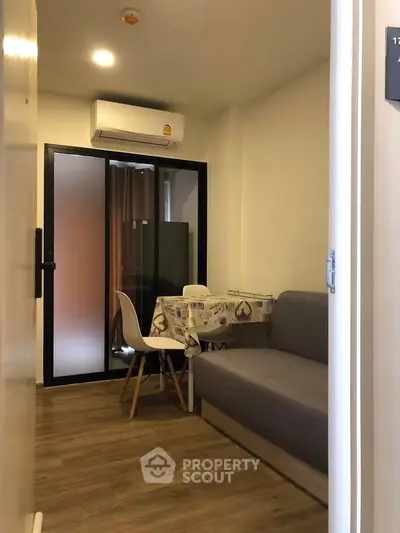 Cozy living room with modern furniture and air conditioning in a compact apartment setting.