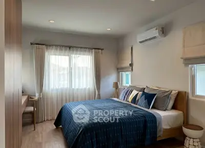 Cozy bedroom with modern decor and natural light, featuring a comfortable bed and stylish window treatments.