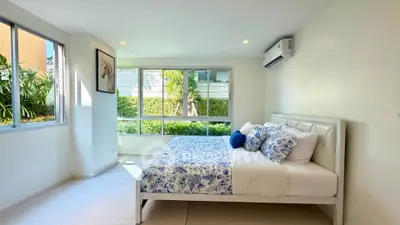 Bright and spacious bedroom with large windows and modern decor.