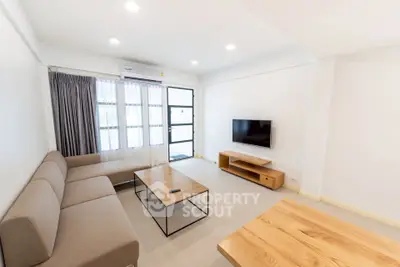 Modern living room with sleek furniture and wall-mounted TV, perfect for relaxation.