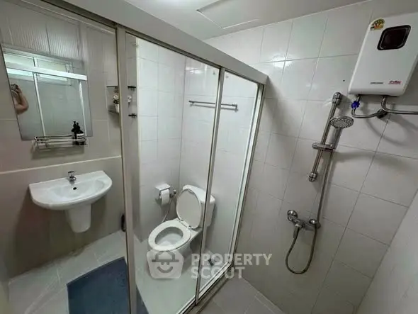 Modern bathroom with shower and sleek fixtures in a compact layout.