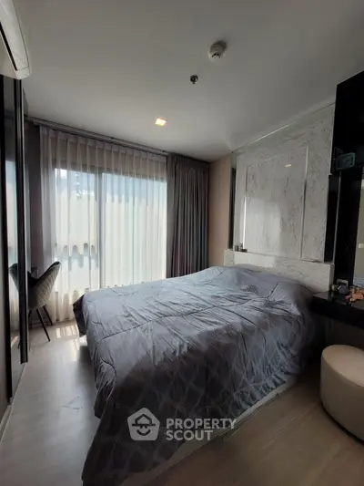 Modern bedroom with large window and elegant decor in a stylish apartment.