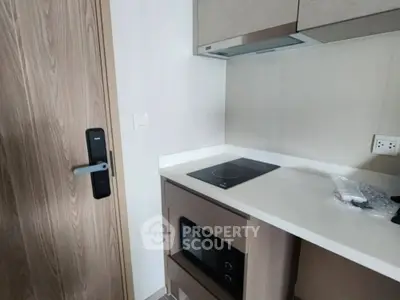 Modern compact kitchen with built-in microwave and electric stove