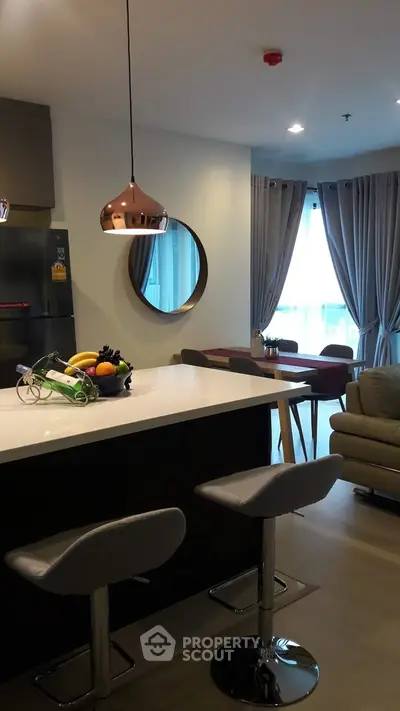 Modern open-layout kitchen with stylish pendant lighting and cozy dining area.