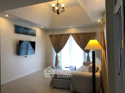 Spacious living room with elegant lighting and large windows for natural light.
