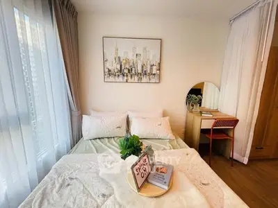 Cozy bedroom with cityscape artwork and natural light