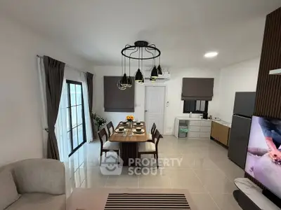 Modern open-plan living and dining area with stylish lighting and contemporary furniture.