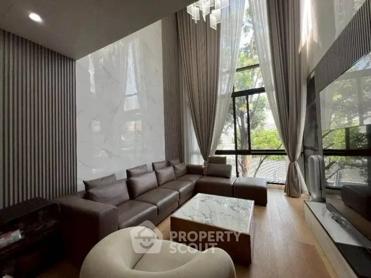 Luxurious modern living room with high ceilings and large windows