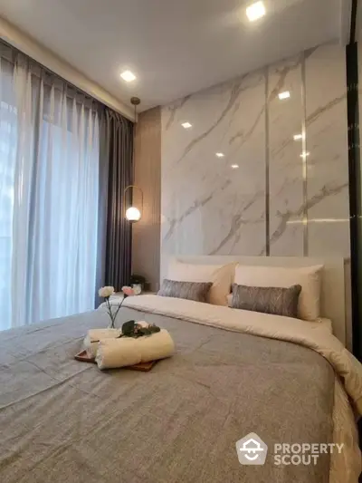 Luxurious bedroom with marble accent wall and cozy lighting