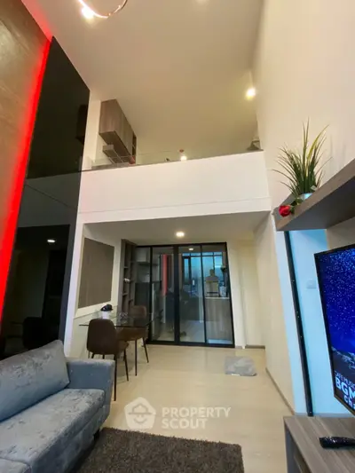 Modern living room with high ceiling and mezzanine, stylish decor and cozy ambiance.