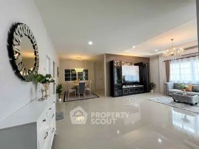 Spacious open-plan living and dining area with elegant decor and modern lighting.