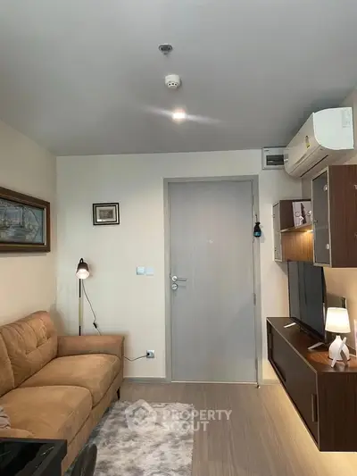 Modern living room with cozy sofa, stylish decor, and entertainment center in a contemporary apartment.