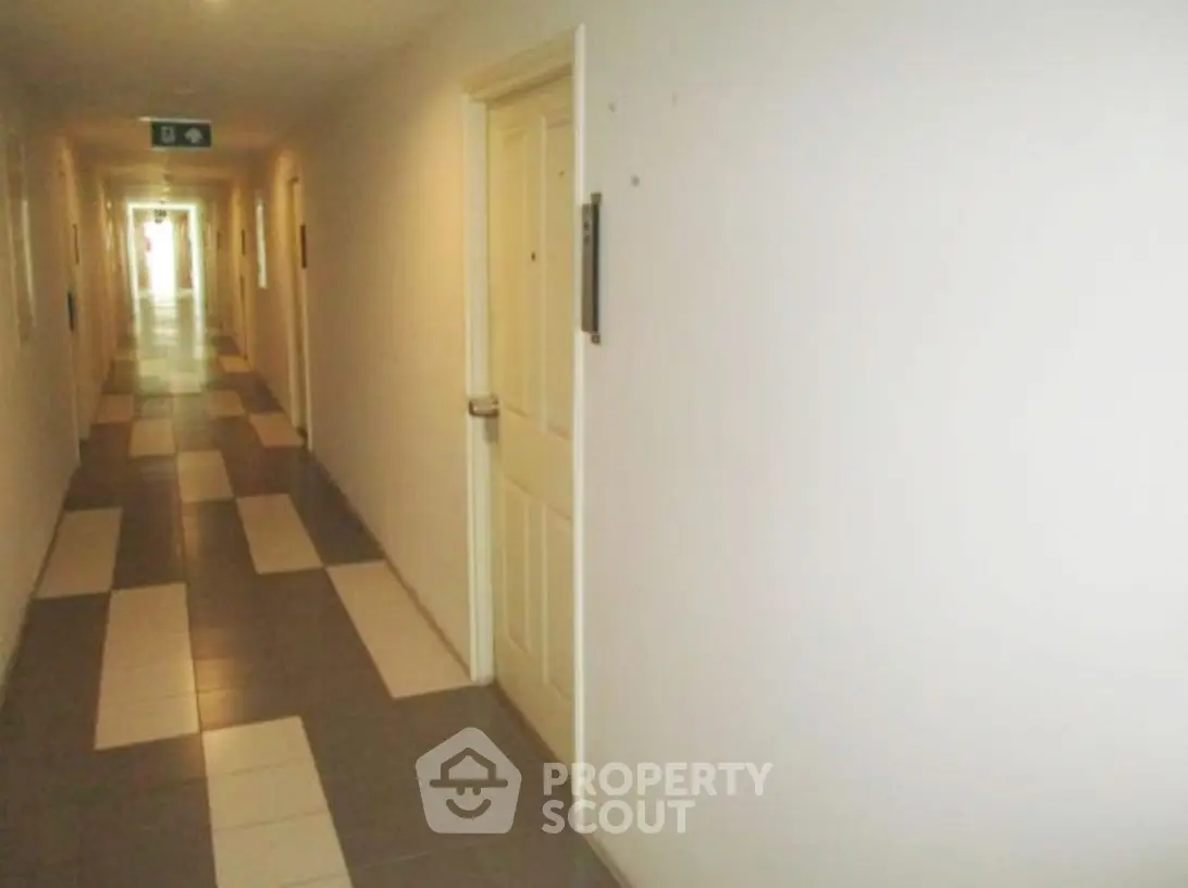 Spacious apartment hallway with modern tile flooring and bright lighting.