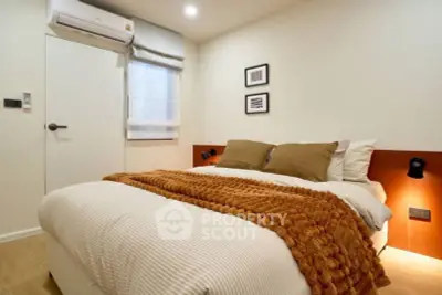 Cozy bedroom with modern decor and warm lighting, featuring a comfortable bed and stylish wall art.