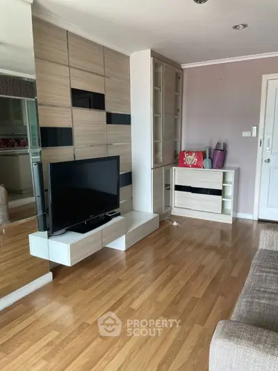 Modern living room with sleek TV unit and wooden flooring, perfect for cozy family gatherings.