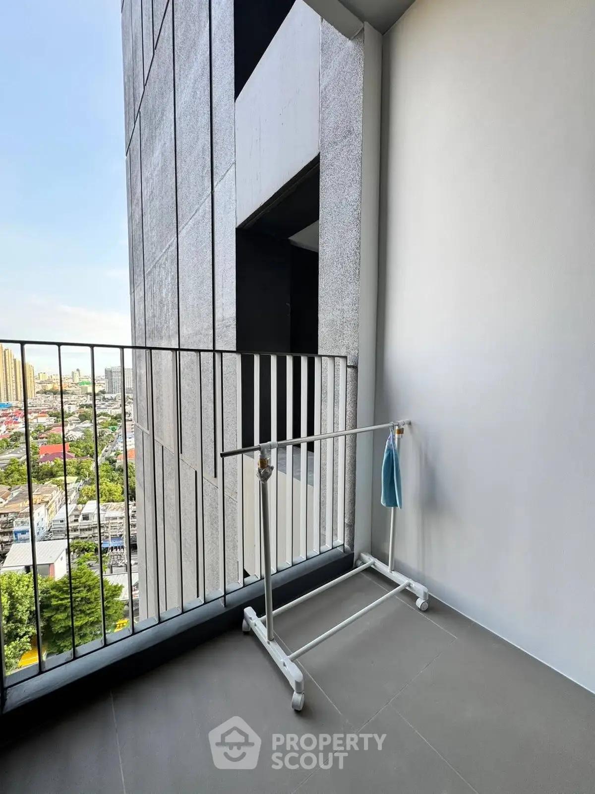 Modern balcony with city view and clothes rack in high-rise building
