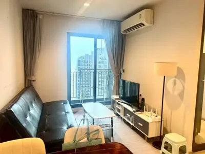 Modern living room with city view, sleek furniture, and natural light