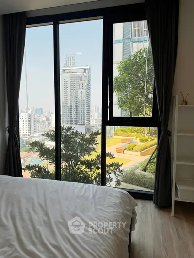 Stunning bedroom view with floor-to-ceiling windows overlooking cityscape and lush greenery.