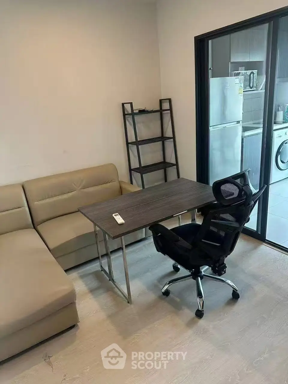 Modern living room with sleek furniture and kitchen view, perfect for urban living.