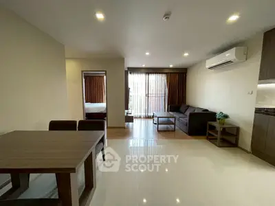 Spacious modern living room with dining area and large windows in a stylish apartment.