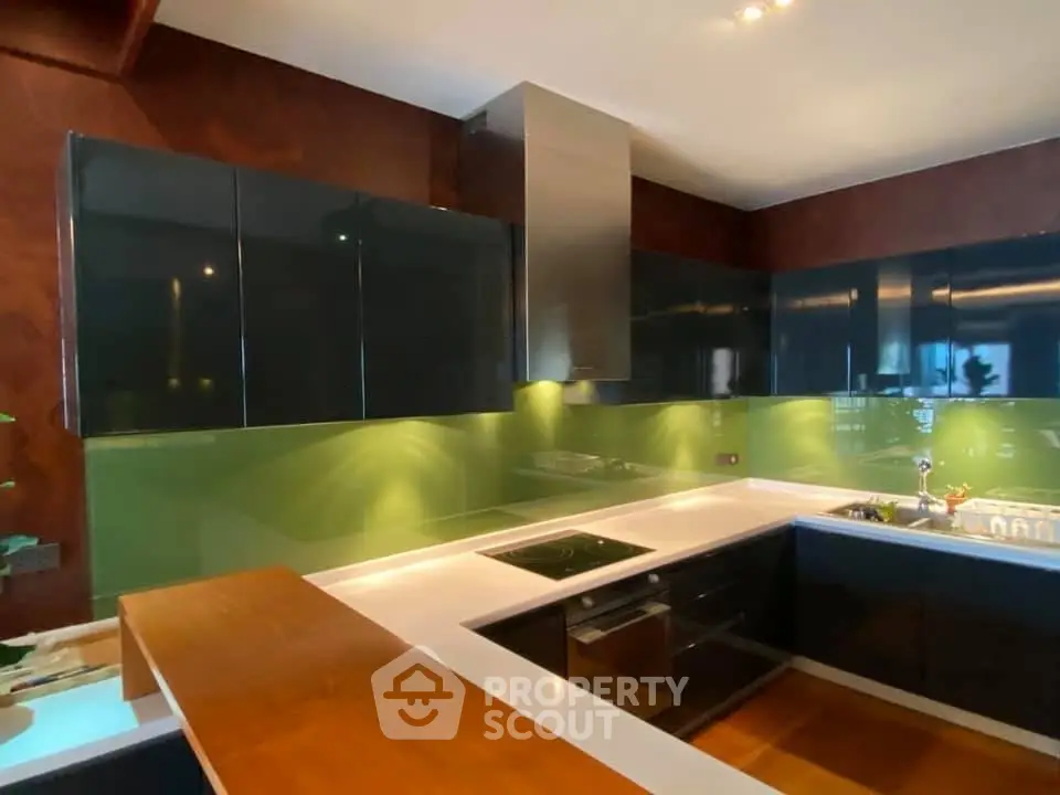 Modern kitchen with sleek cabinetry and green backsplash