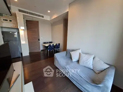 Modern living room with sleek furniture and open kitchen layout in a stylish apartment.