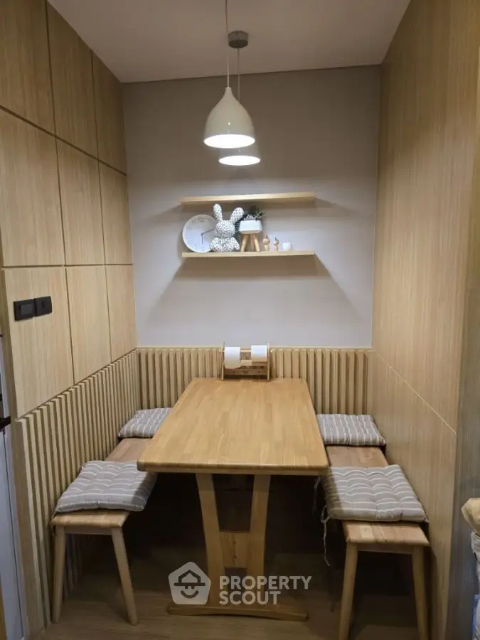 Cozy wooden dining nook with modern lighting and minimalist decor