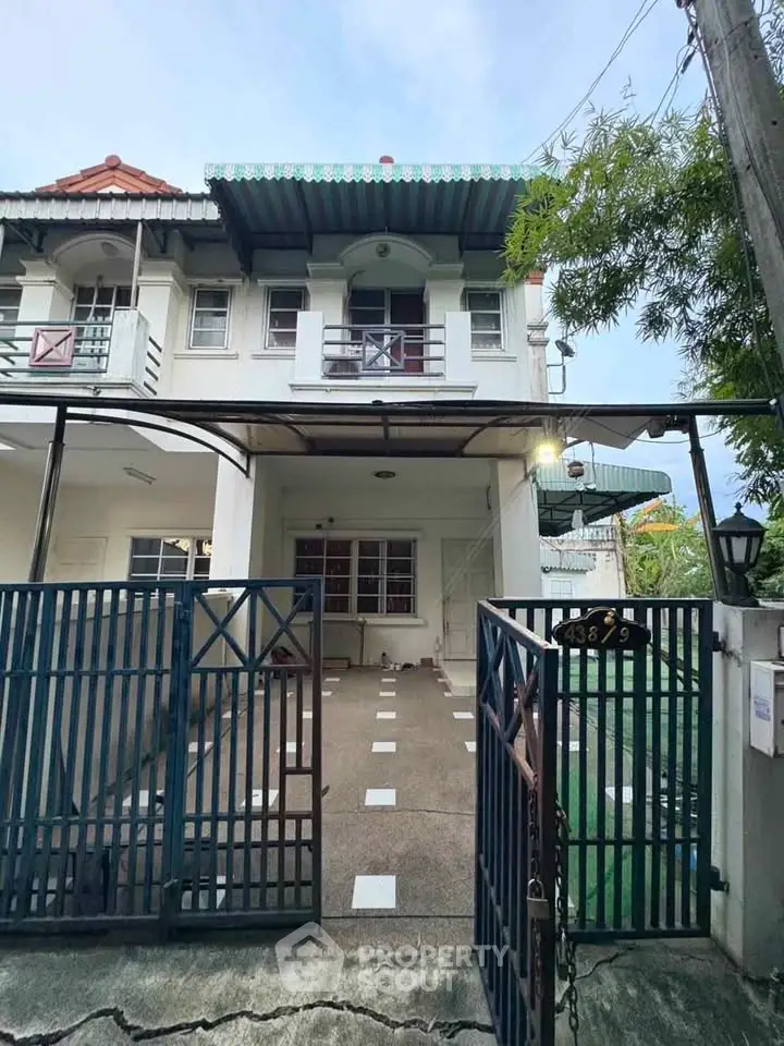 Charming two-story townhouse with gated driveway and balcony, perfect for family living.