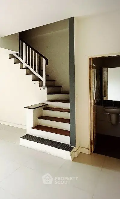 Modern interior with staircase and small bathroom, ideal for compact living spaces.