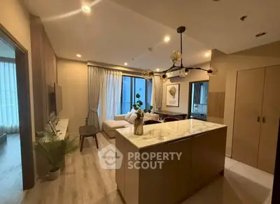 Modern open-layout living room with stylish lighting and cozy seating area, perfect for urban living.