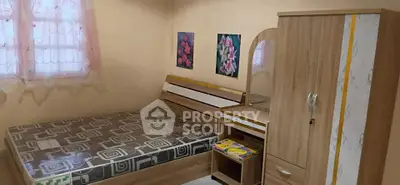 Cozy bedroom with wooden furniture and floral wall art, perfect for relaxation.