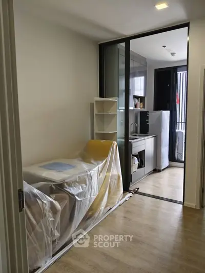 Modern compact kitchen with sleek design and sliding glass door, perfect for urban living.