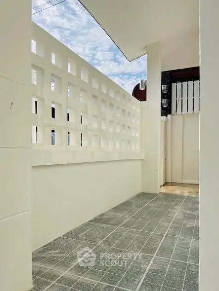 Charming outdoor entrance with modern lattice wall and tiled flooring, perfect for a welcoming entryway.